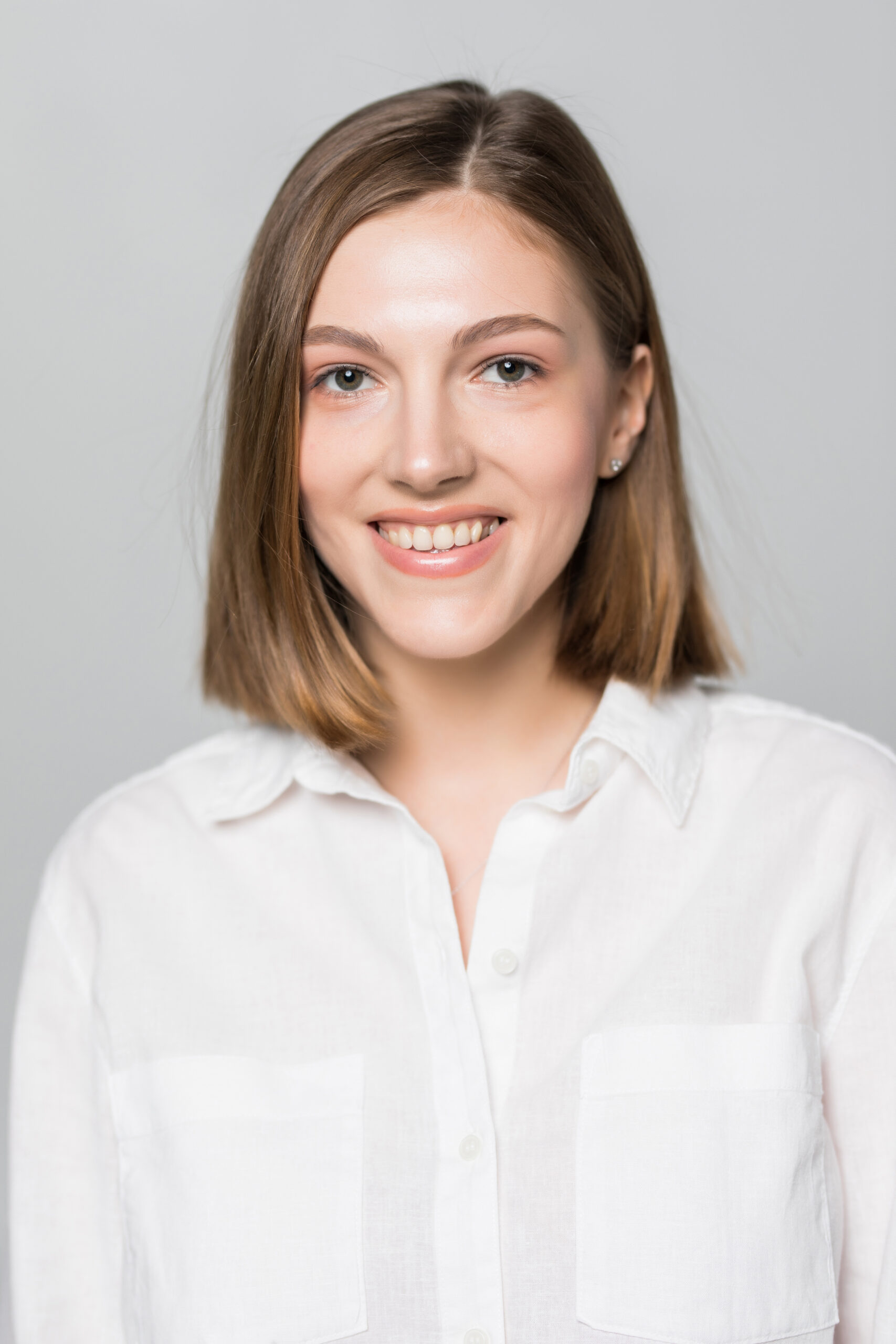 Smiling business woman against white background.